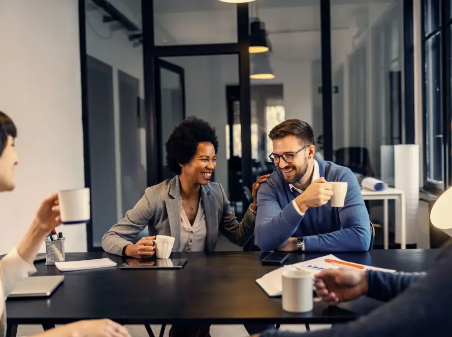 Colleagues sharing a light moment during a meeting in a modern office.