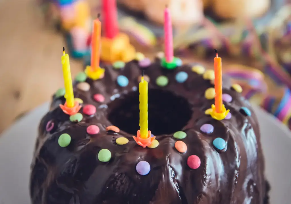 Chocolate cake with colorful candles and sprinkles.