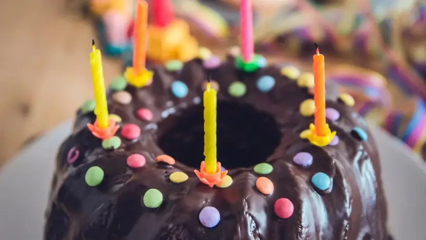 Chocolate cake with colorful candles and sprinkles.