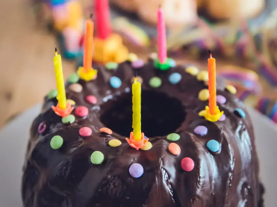 Chocolate cake with colorful candles and sprinkles.