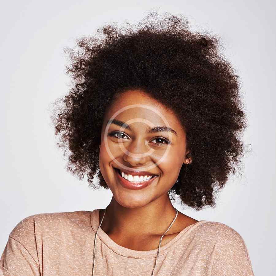 Smiling woman with natural afro hairstyle and glasses.
