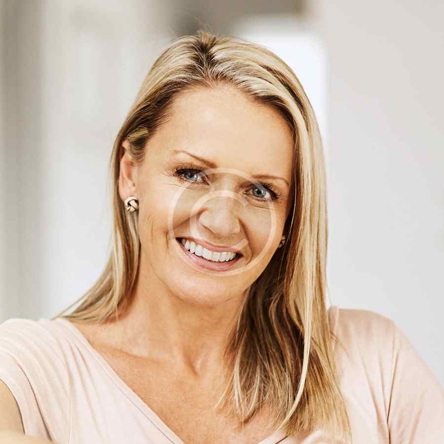 Smiling blonde woman in a light-colored top.