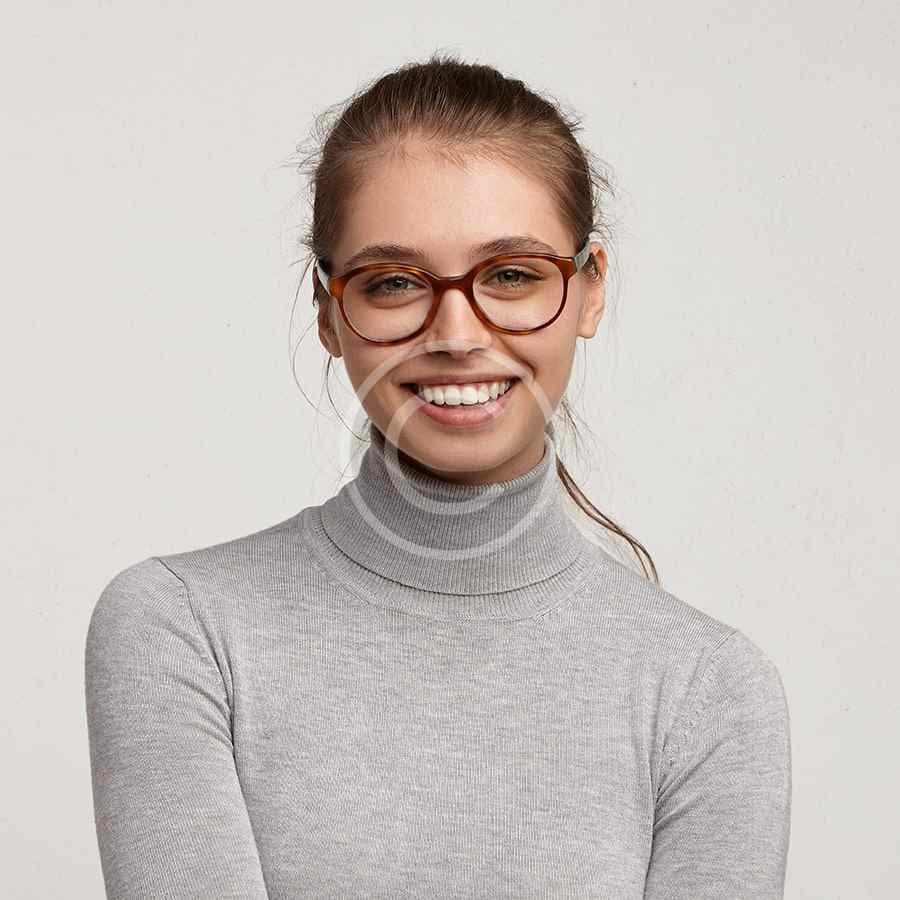 Smiling woman wearing glasses and a gray turtleneck sweater.