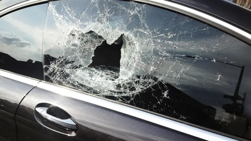 Car window shattered with a large hole in the glass.