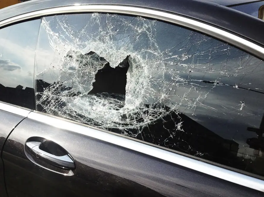 Car window shattered with a large hole in the glass.