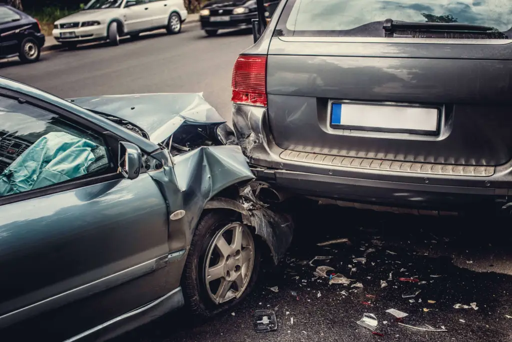 Two cars involved in a rear-end collision on a street.