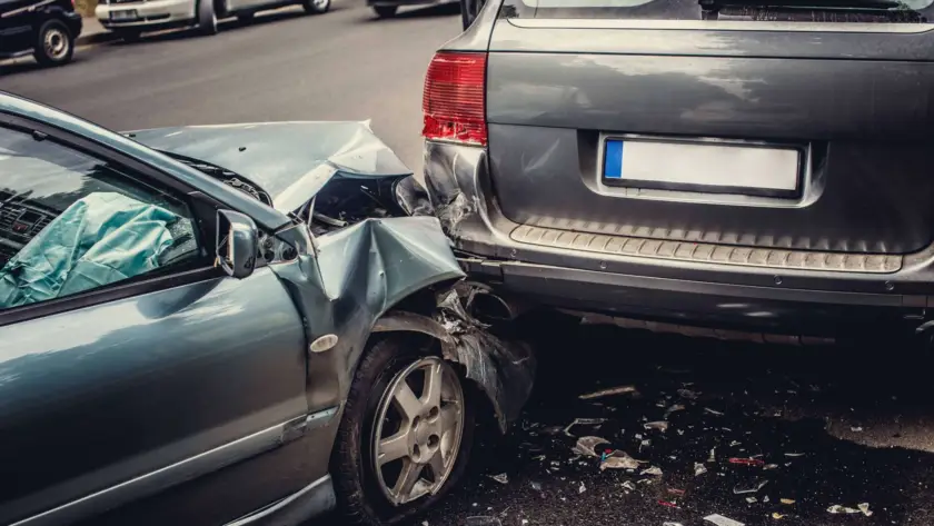 Two cars involved in a rear-end collision on a street.