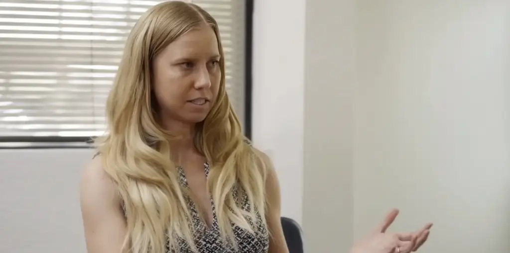 Woman with long blonde hair looking skeptically to the side.