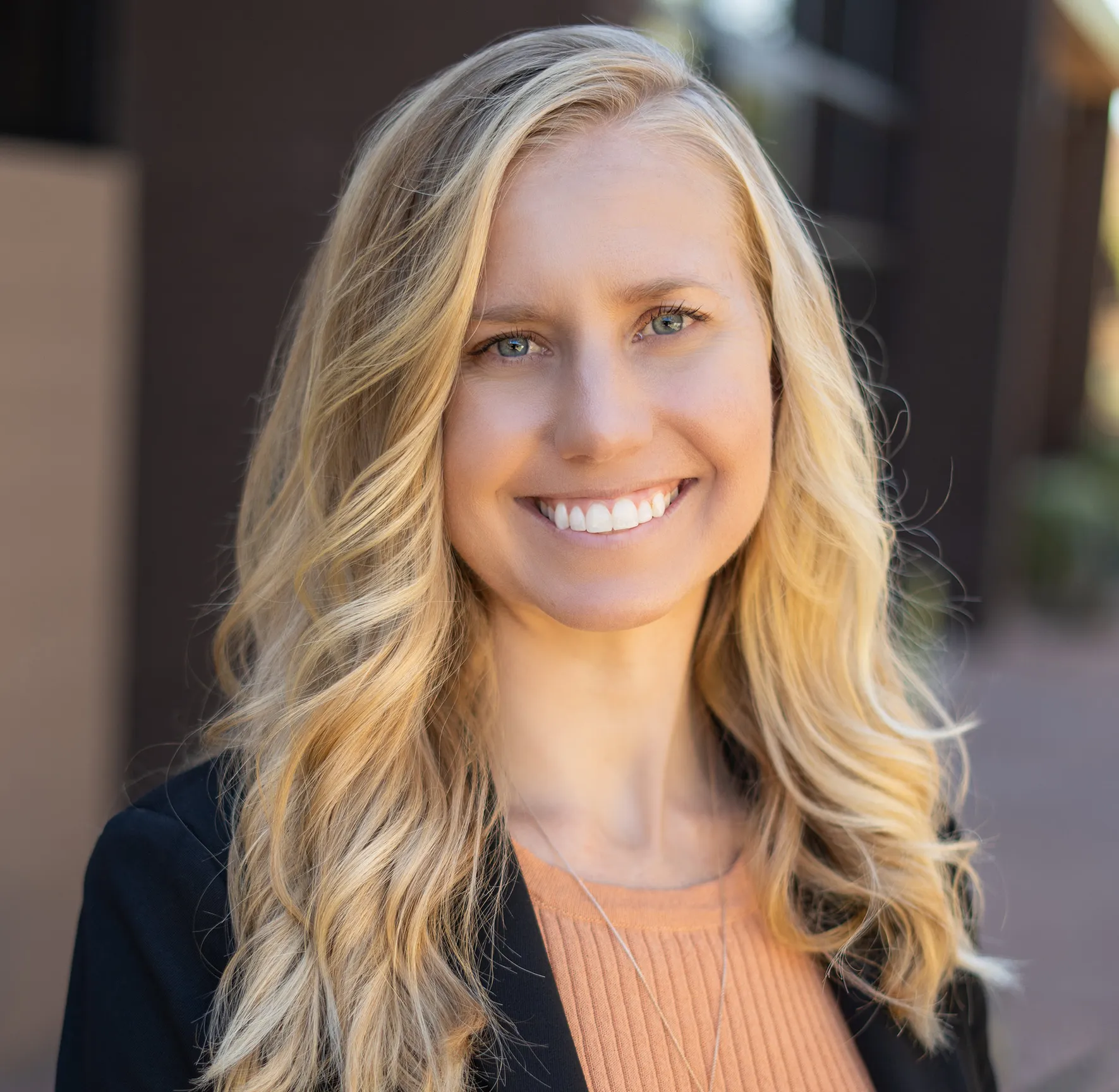 Smiling woman with long blonde hair in a professional setting.