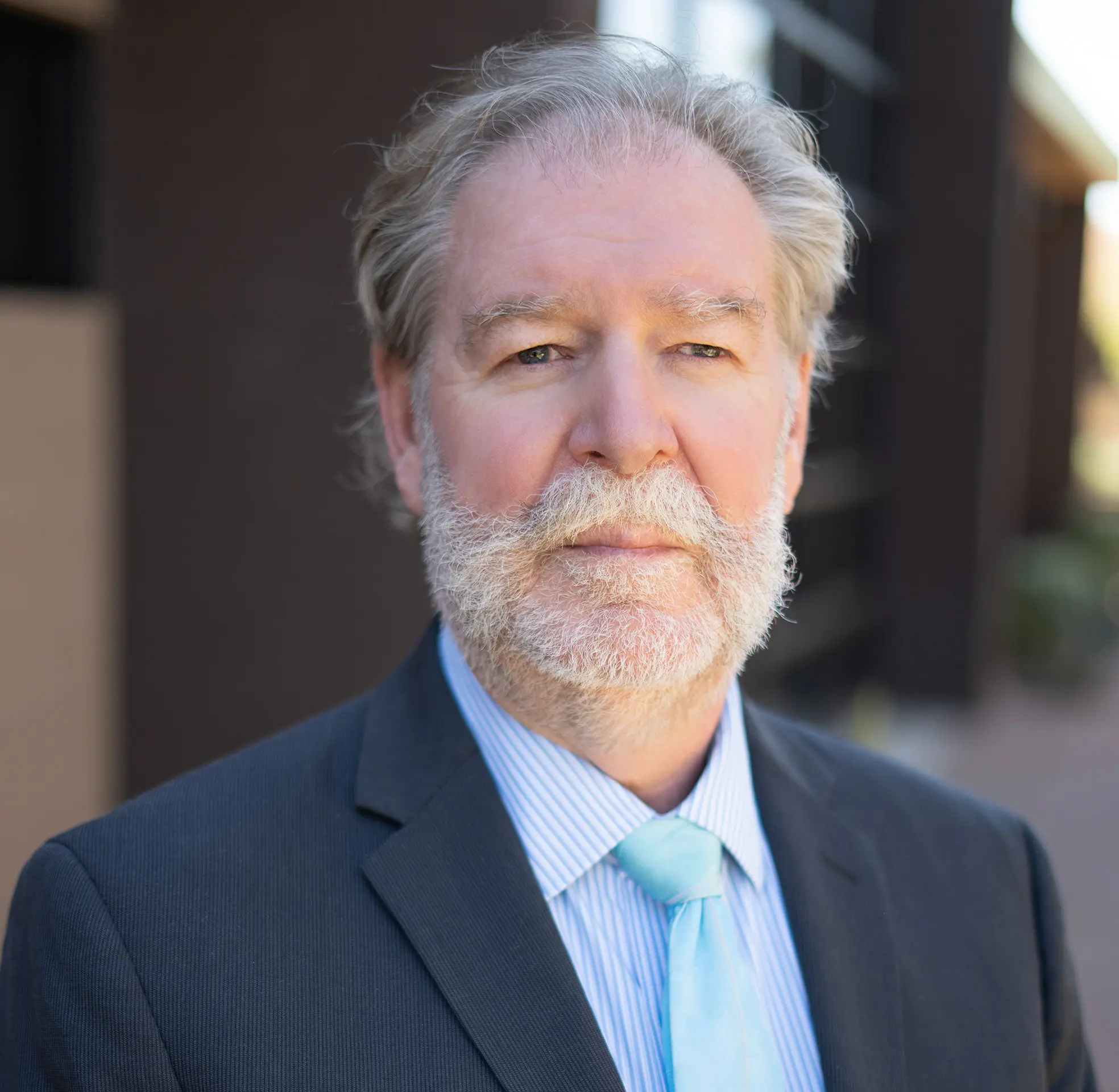 Older man in a suit with a beard and mustache.