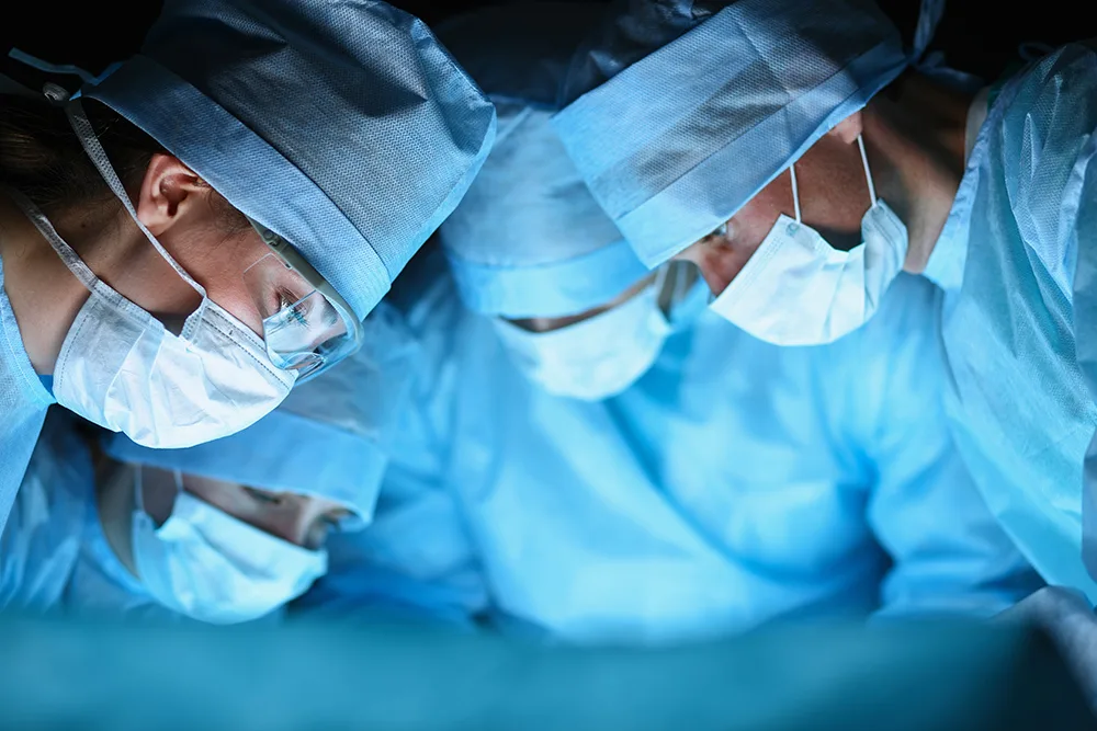 Surgeons focused on a complex operation in a bright, sterile operating room.