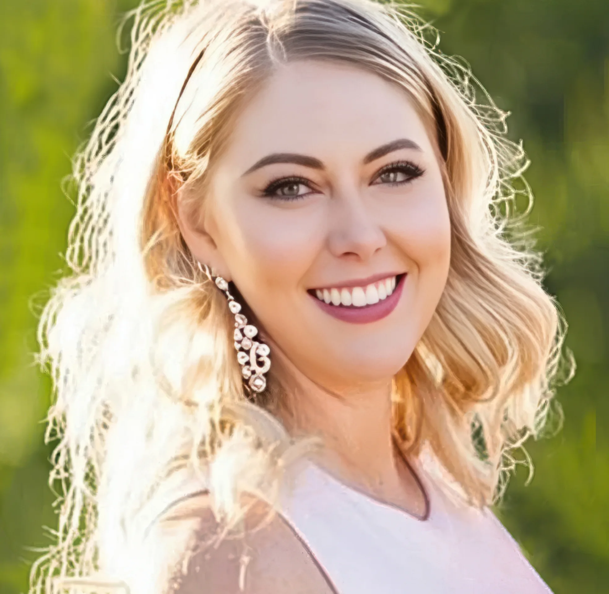 Smiling woman with blonde hair in outdoor sunlight.