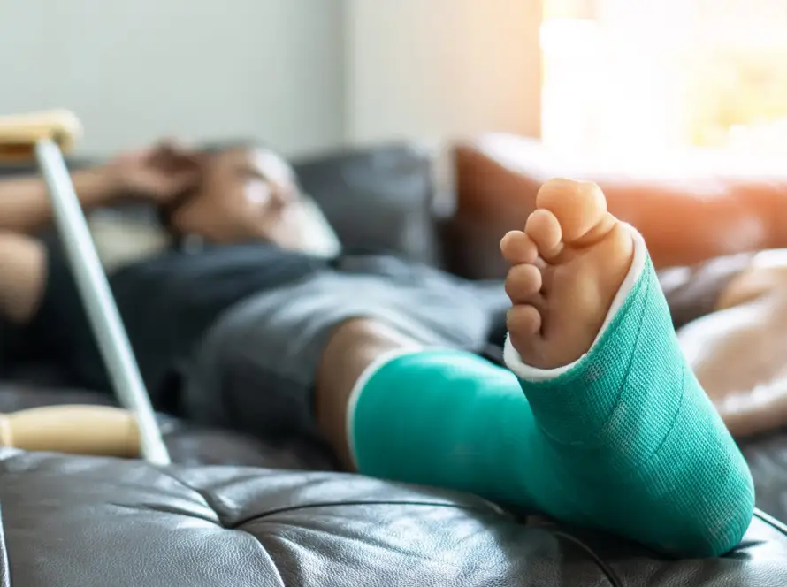 Person resting with a green cast on their foot, using crutches.