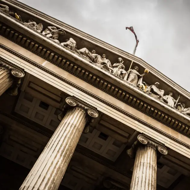 Classical building facade with ornate sculptures and tall columns.